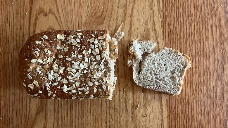 A multigrain pan loaf is dotted with oats