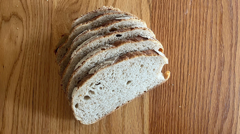 A sliced loaf of Mt. Athos sourdough from Whole Foods sits on a wooden table