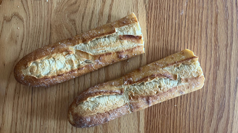 A baguette rests on a wooden table