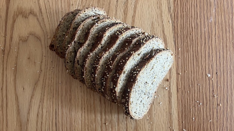 A seedy loaf of bread is cut into slices