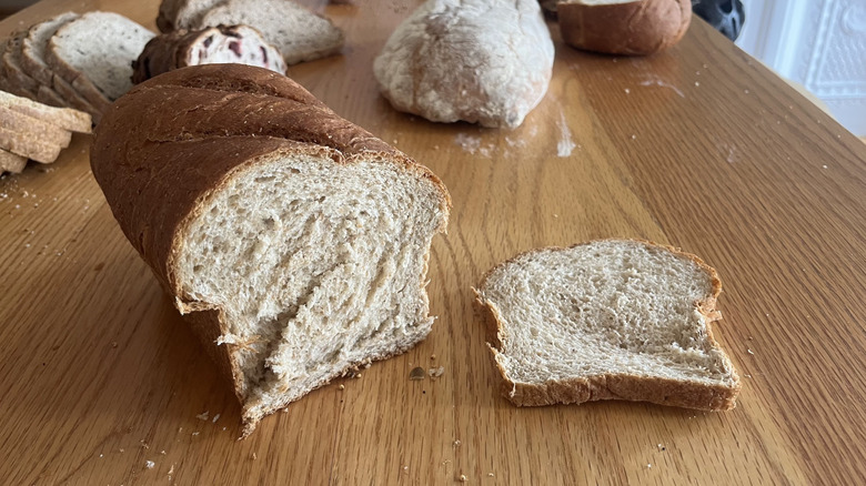 A pan loaf is cut and displayed next to a slice of itself