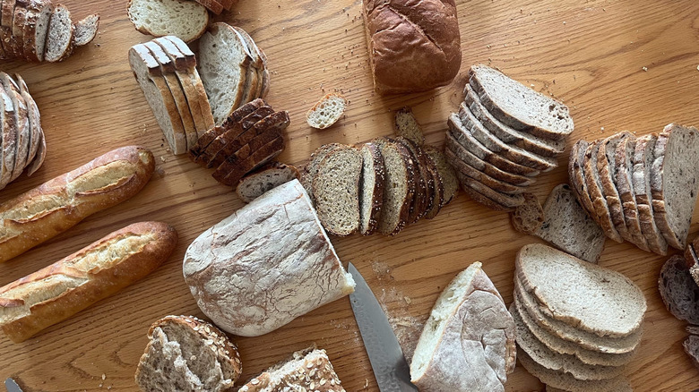 An array of breads sit on a wooden background