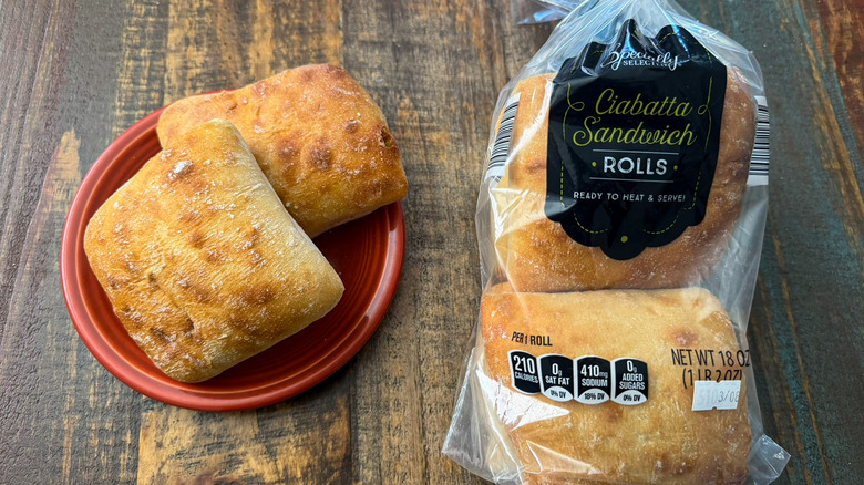 A package of Aldi Specially Selected Ciabatta Sandwich Rolls next to a plate with two rolls on it