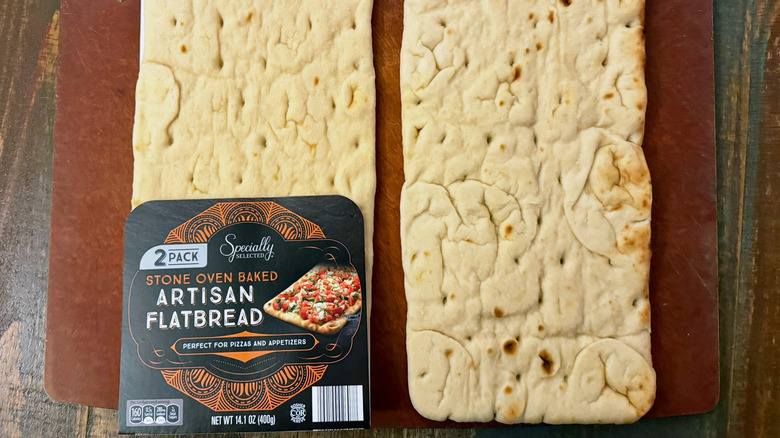 Aldi Specially Selected Artisan Flatbread in and out of the packaging, shot overhead on a wood background