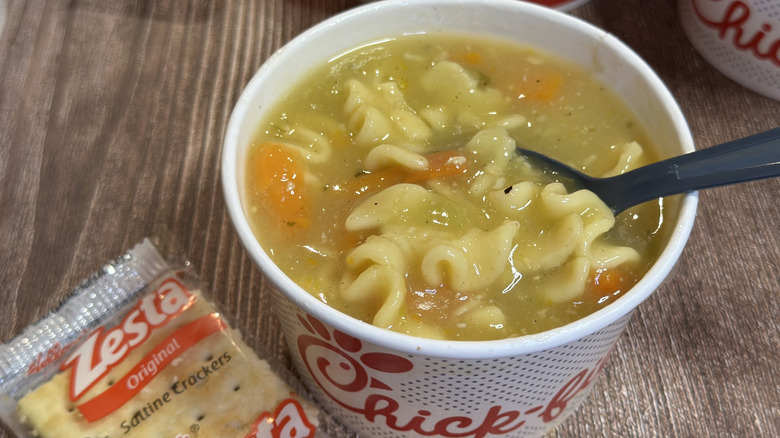 Chick-fil-A Cup of Chicken Noodle Soup with a spoon and a side of crackers