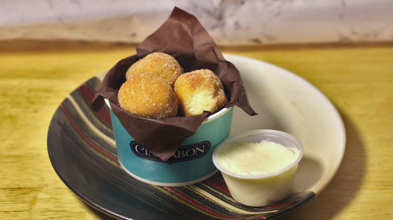 A cup of Cinnabon's CinnaSweeties set onto a plate
