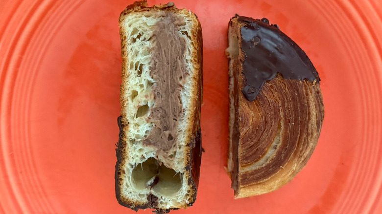 A chocolate supreme croissant from Paris Baguette split open on plate