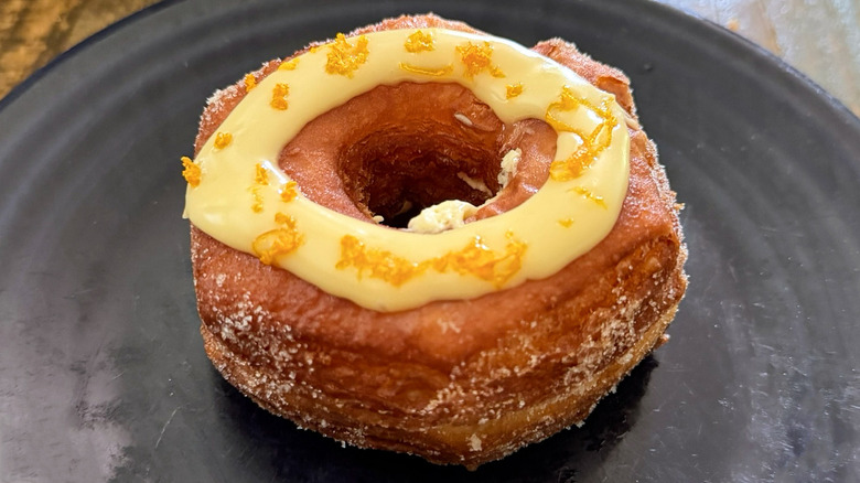A croissant donut from Paris Baguette with ring of lemon glaze on plate