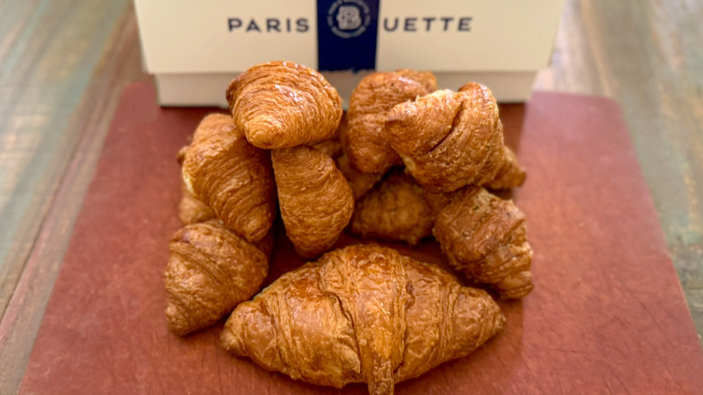 A pile of croissants from Paris Baguette with bakery box in background