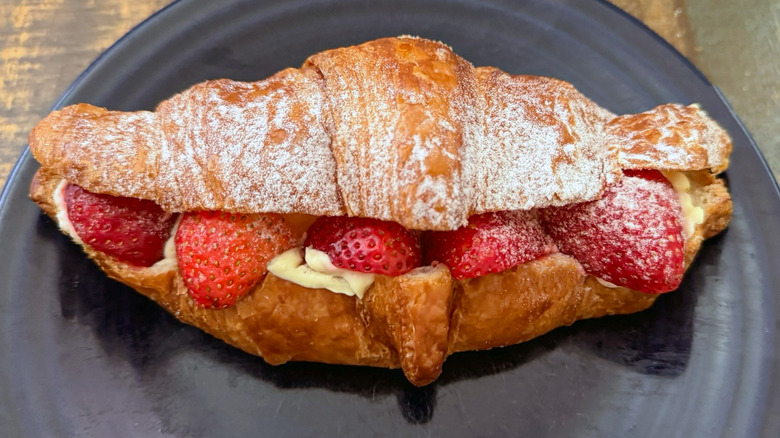 A strawberry croissant stuffed with fresh strawberries and cream from Paris Baguette on plate