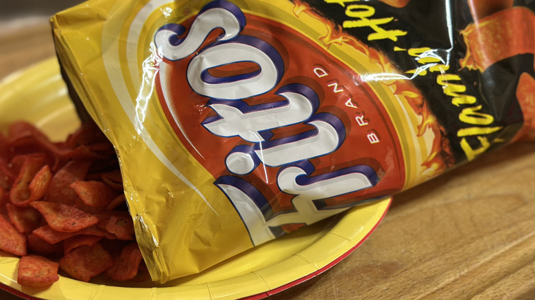 Flamin Hot Fritos bag with chips spilling out onto a plate