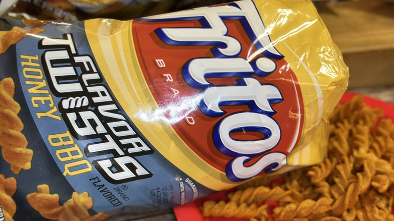 Fritos Flavor Twists Honey BBQ bag with fritos spilling out onto a red paper plate