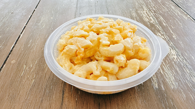 KFC Mac and Cheese in plastic packaging on wooden table