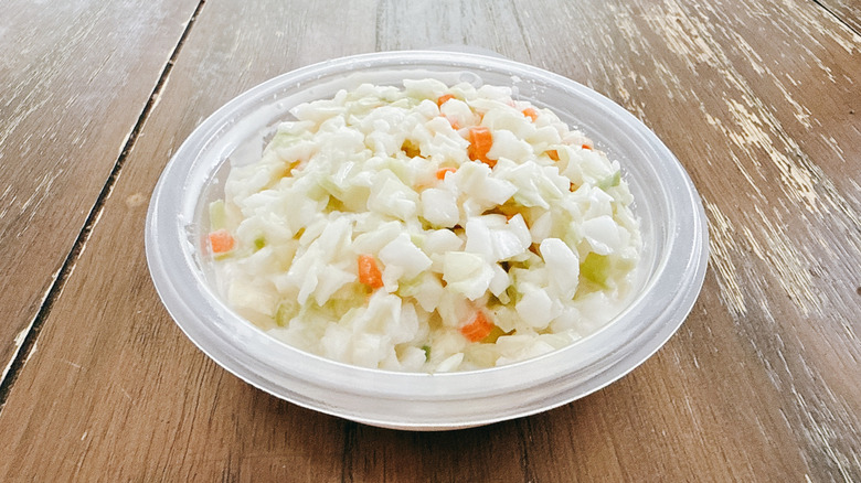 KFC Coleslaw in plastic container on wooden table