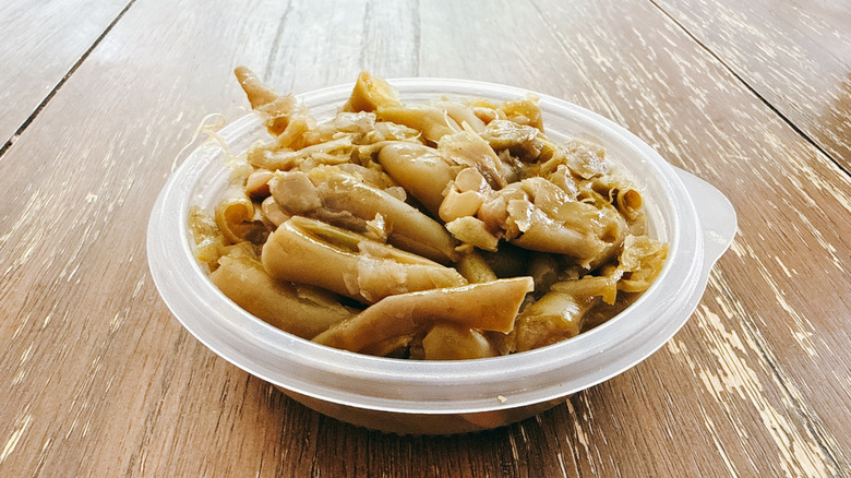 KFC green beans in plastic container on wooden table