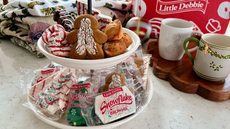 A tiered tray filled with a variety of Little Debbie Christmas snack cakes and cookies