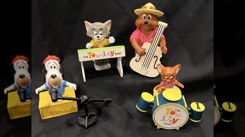 Four brightly colored figurines of Tom, Jarry, and friends, playing in a band