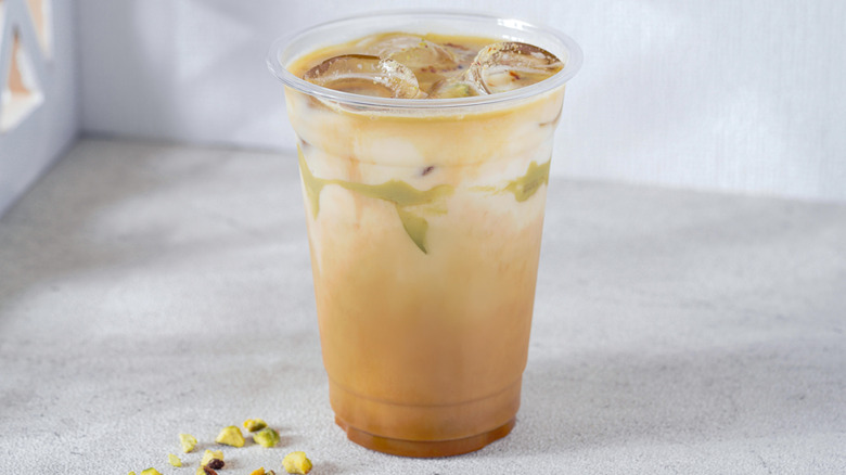Pistachio milk coffee in clear plastic cup