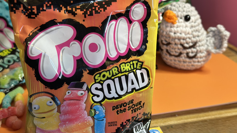 Close up of Trolli Sour Brite Squad package with crochet bird in background