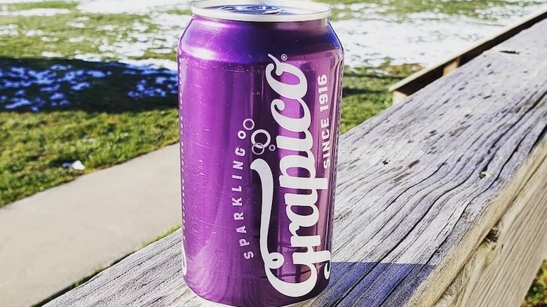 A can of Grapico on a wooden fence outdoors