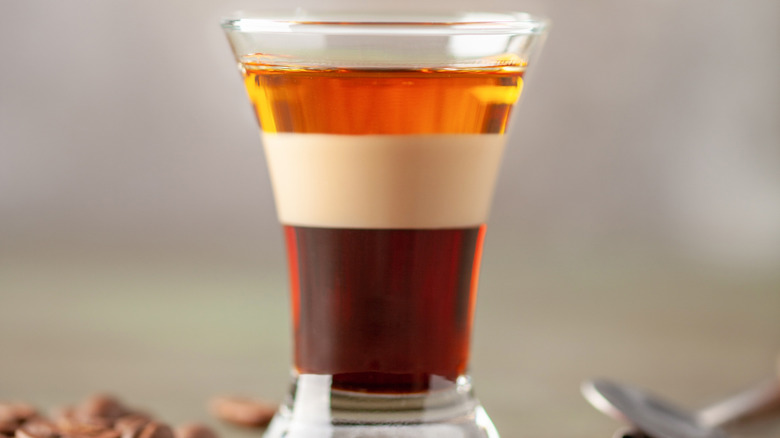 Duck fart layered shot, with three layers of dark liquids in shot glass