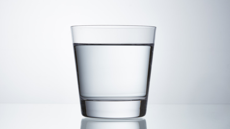 A glass of still water on gray background