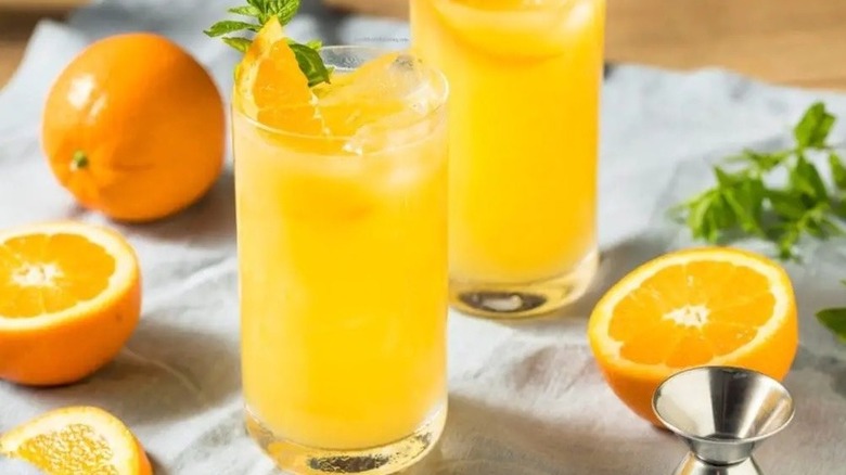 Two glasses of orange crush cocktails with oranges