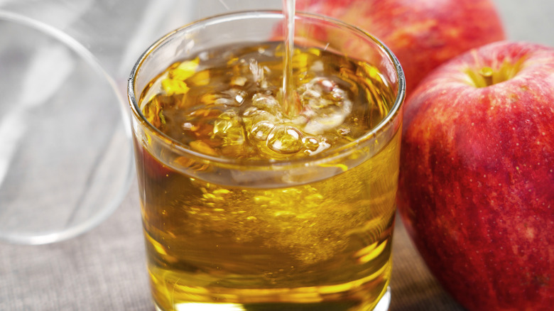 Apple cider in a glass with apples