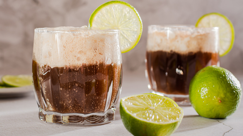Two glasses of dirty soda with lime