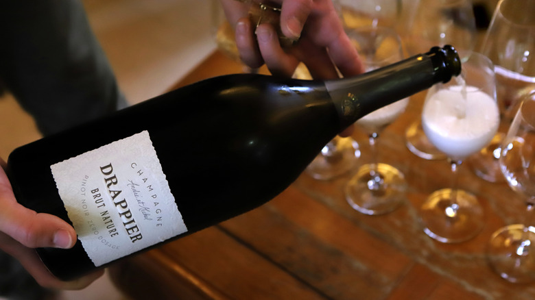 Bottle of brut nature Champagne poured into glass