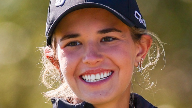 Kai Trump smiling on a golf course