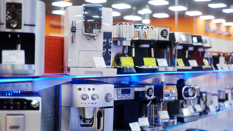 Various coffee machines with several features in row on display in store