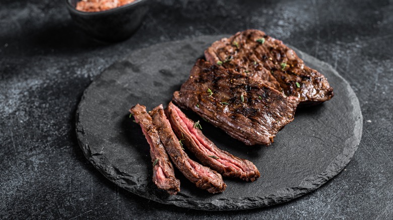 Sliced skirt steak on slate serving board