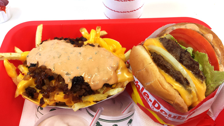 Animal-Style Fries next to a Animal-Style Double-Double from In-N-Out on a red tray