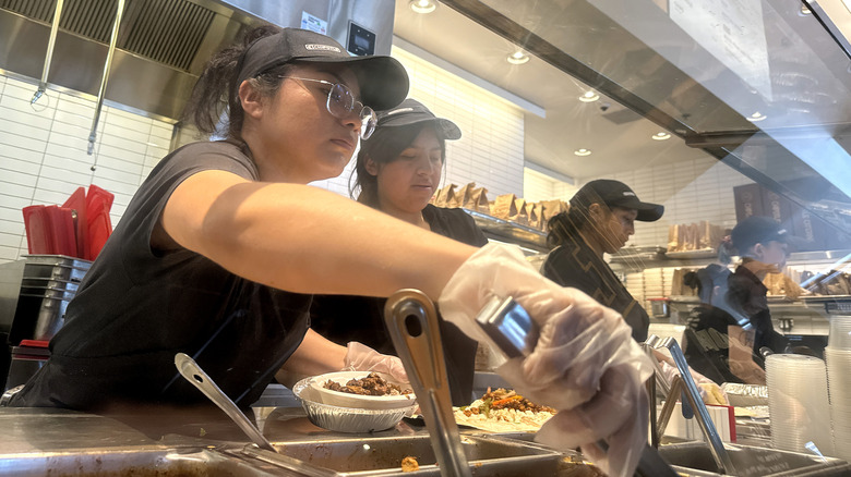 uniformed workers at a Chipotle restaurant assembling bowls