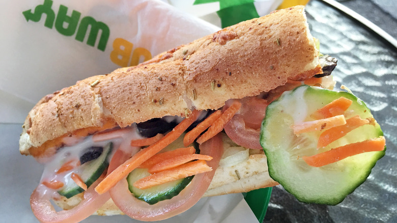 A Subway sandwich on a wrapper on a table.