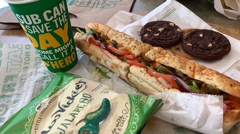 Subway veggie sandwich with jalapeno chips, drink, and chocolate cookies