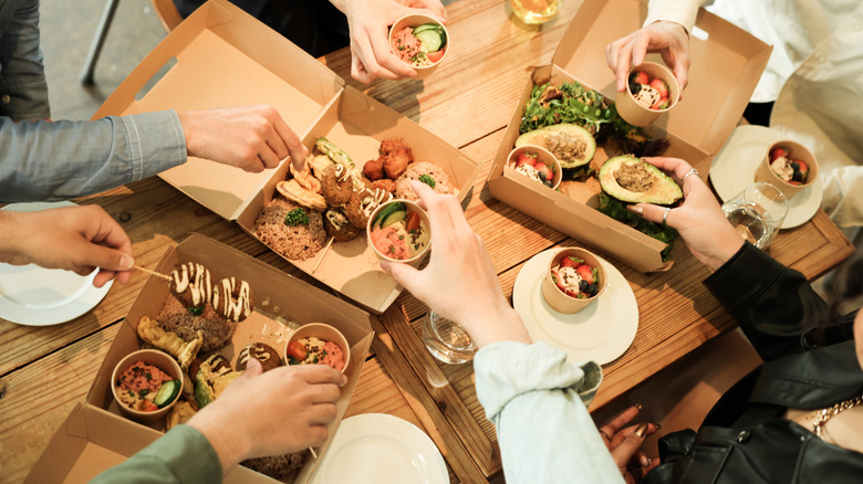 Friends eating takeout food at home