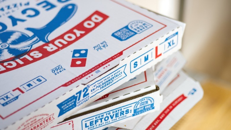 Stacked Domino's pizza boxes.