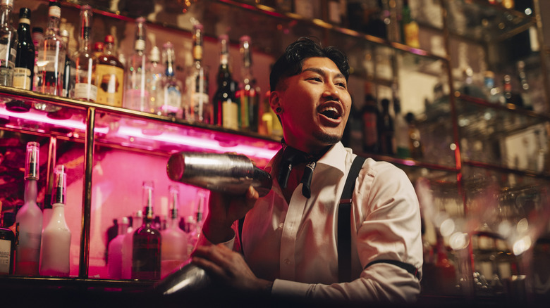 A bartender shakes two drinks at once