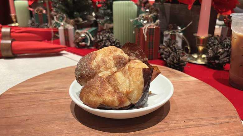 A close-up of cinnamon pull-apart bread from Starbucks in front of a holiday-themed background