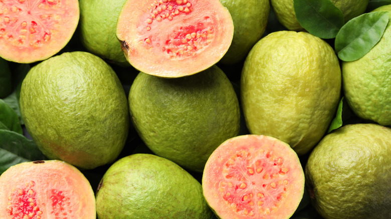 Fresh cut and whole guava fruits as background,