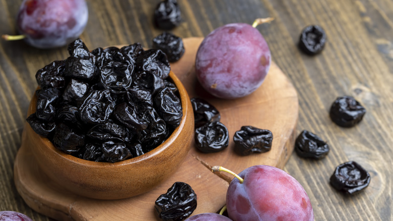a pile of prunes on a wooden table in the kitchen close-up