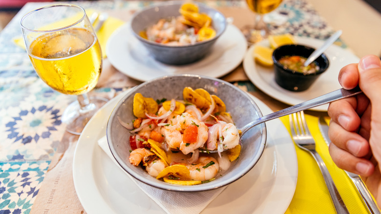 Shrimp ceviche, served with red onion, lime, herb sauce, and tomatoes
