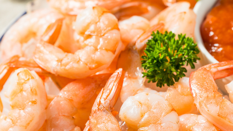 Cooked shrimp with sauce and a sprig of parsley