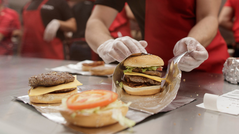 An employee wrapping a Five Guys burger up in foil.