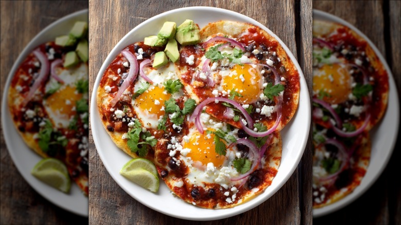 Huevos rancheros stacked on a plate with a wooden background