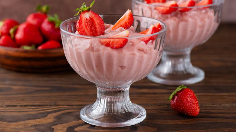 Two goblets with pink creamy dessert with fresh strawberries