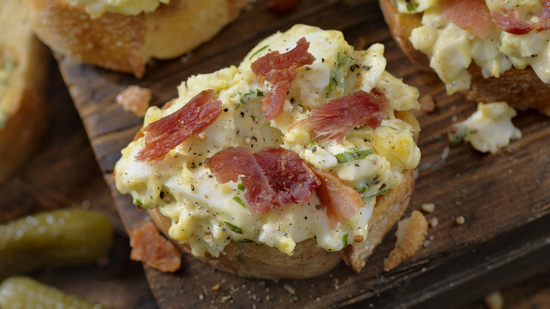 Egg salad and bacon pieces on crostini