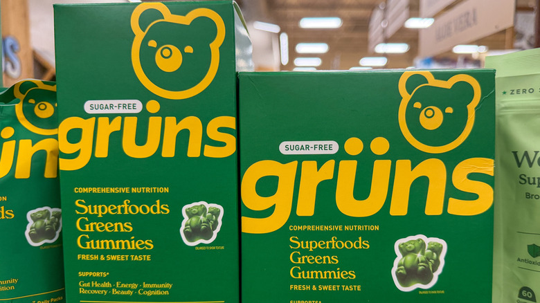 Boxes of Grüns superfoods greens gummies on a store shelf.